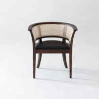 A dark wooden chair with a curved backrest and cane webbing, featuring a black cushioned seat, is positioned on a light, plain background.