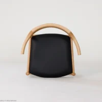 A modern chair with a curved wooden frame and a black cushioned seat, set against a plain white background.