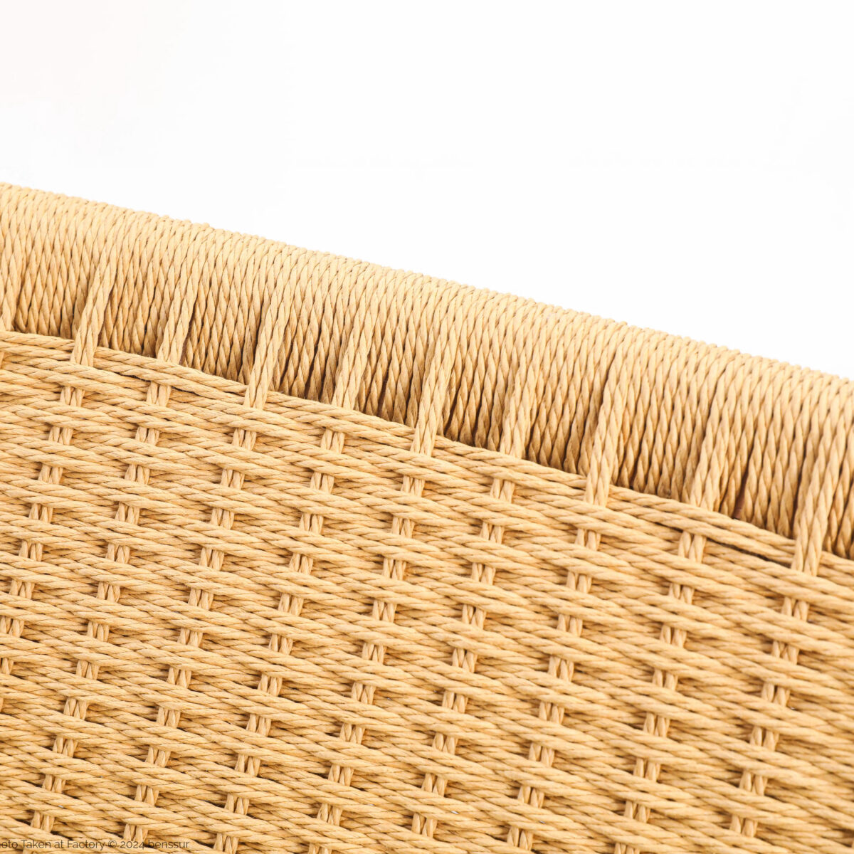 Easy Chair_B4 Close-up view of a woven rattan or wicker surface, showing detailed textured pattern in light tan colour against a white background.