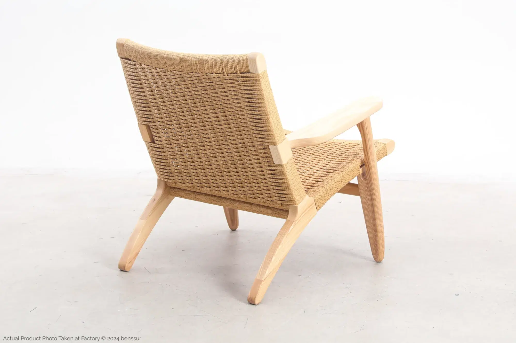 Hans Wegner_CH25 Easy Chair_Replica_Paper Rope_Natural_Ash_Back Right Back-side view of Hans Wegner's CH25 Easy Chair, showcasing the woven paper cord backrest and the sleek wooden frame.