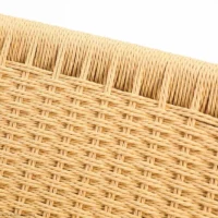Close-up view of woven wicker or rattan material in a light tan colour, showing the detailed texture and pattern of the interlaced strands.