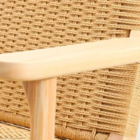 Close-up of a wooden chair armrest and woven rattan seat and backrest, showcasing the detailed weaving and smooth, light wood finish.