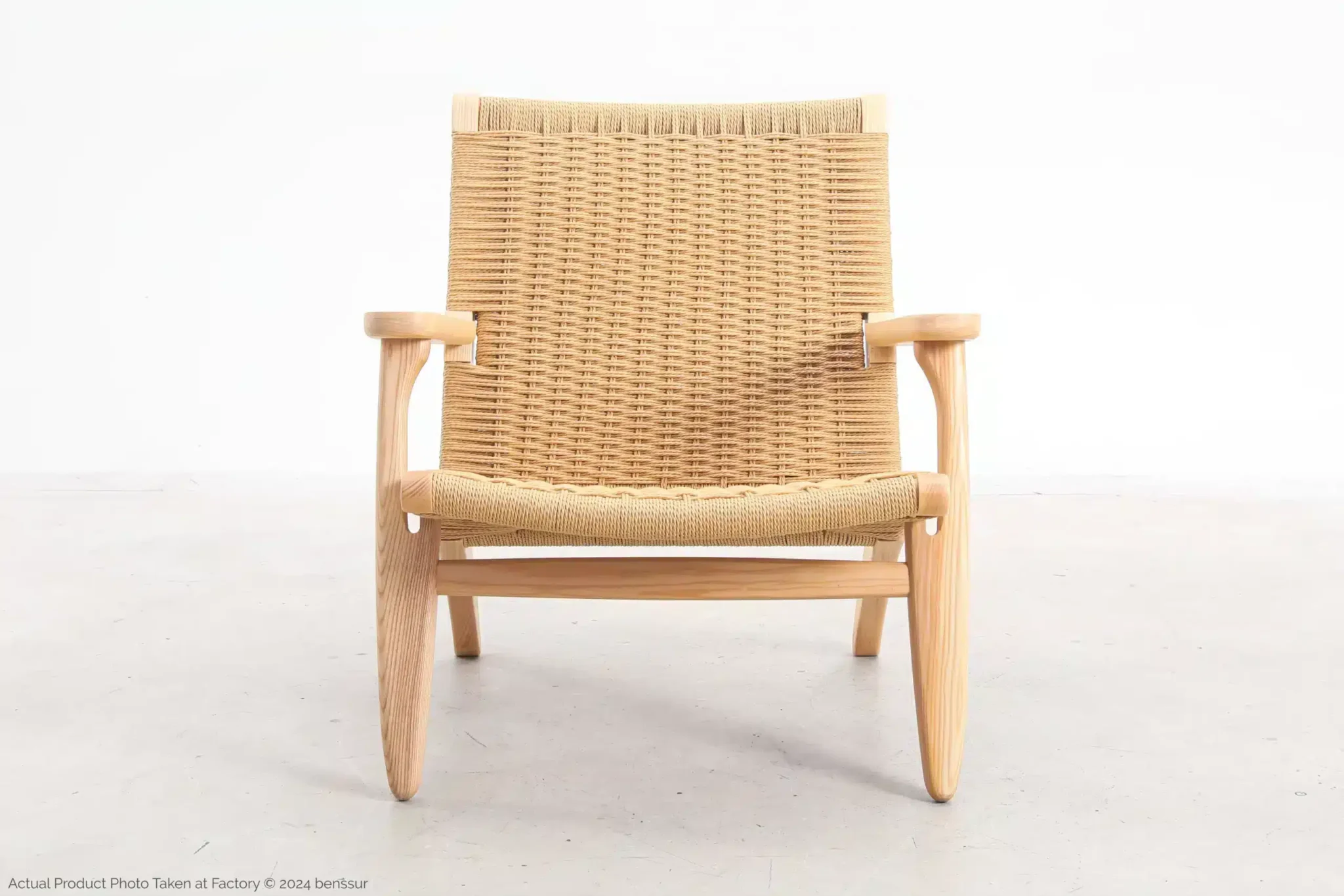 A wooden lounger with a light wood frame and woven rattan seat and backrest, photographed against a plain white background.
