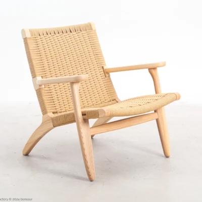 ront-side view of Hans Wegner's CH25 Easy Chair, showcasing its woven seat and backrest along with the solid wooden frame.