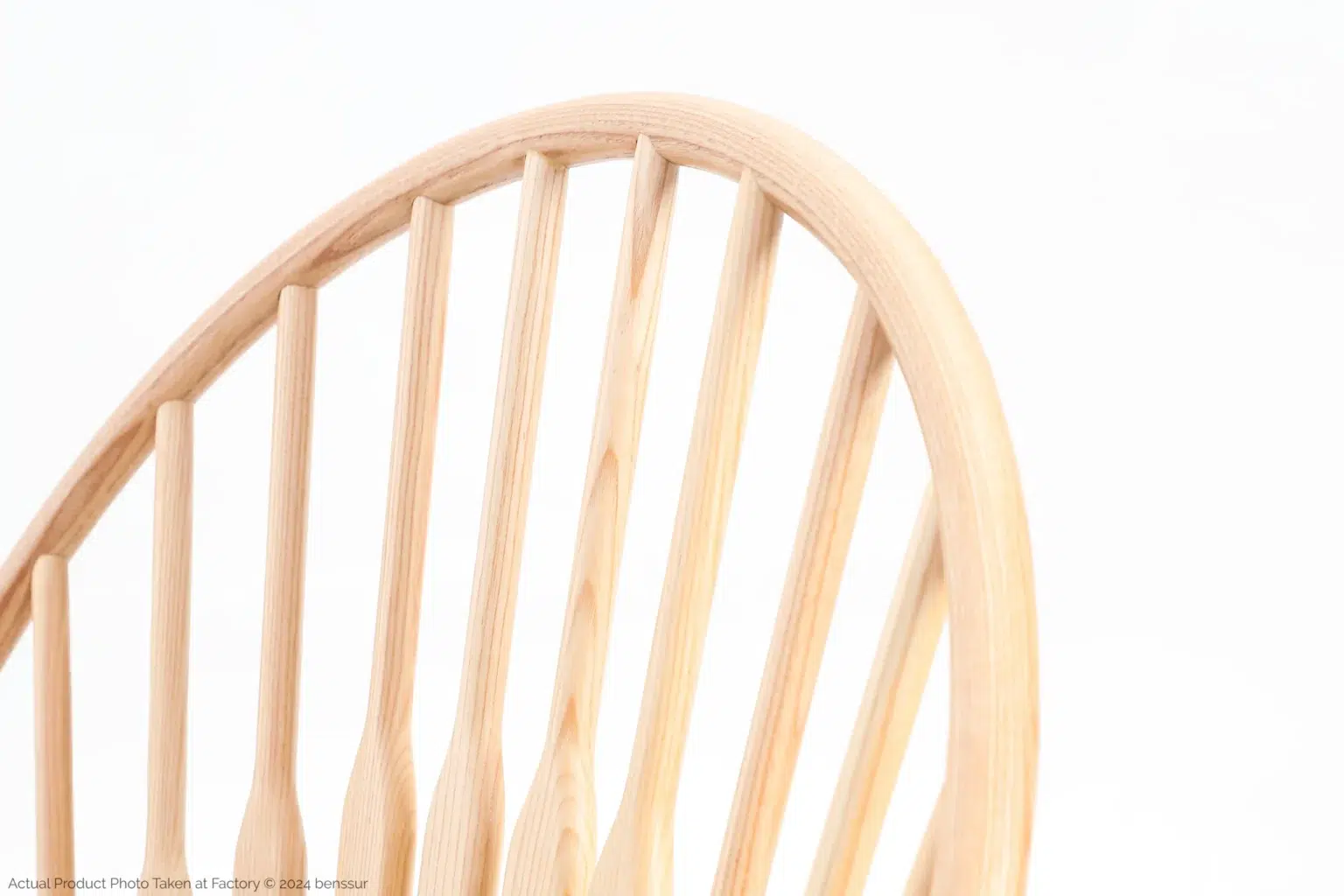 Hans Wegner_Peacock Chair_Replica_Paper Rope_Natural_Ash_Detail_4 Close-up of the upper half of a wooden chair backrest with vertical spindle slats, set against a plain white background.