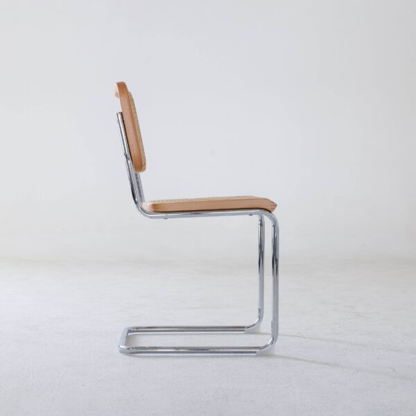 A side view of a modern chair with a chrome cantilever frame and tan leather seat and backrest, set against a plain white background.