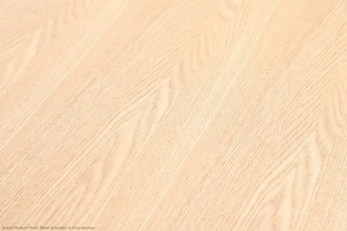 Jean Prouvé_S.A.M No.502 Table_Replica_Natural_Ash_Detail_3 Light-coloured wooden surface with a smooth finish and visible wood grain patterns running diagonally across the image. The texture appears natural and clean, suitable for flooring or furniture.