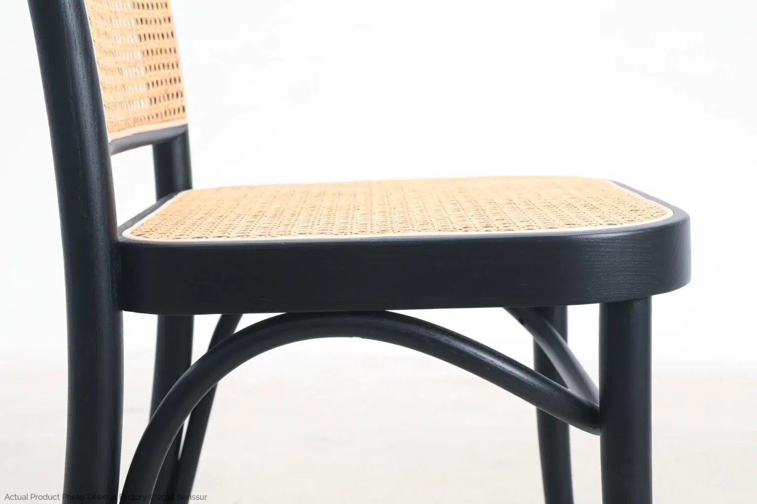 Josef Hoffmann_No811 Chair_Replica_Woven Caning_Black_Ash_Detail_1 A close-up side view of a chair with a woven cane seat and backrest, featuring a black wooden frame and curved legs, against a plain white background.
