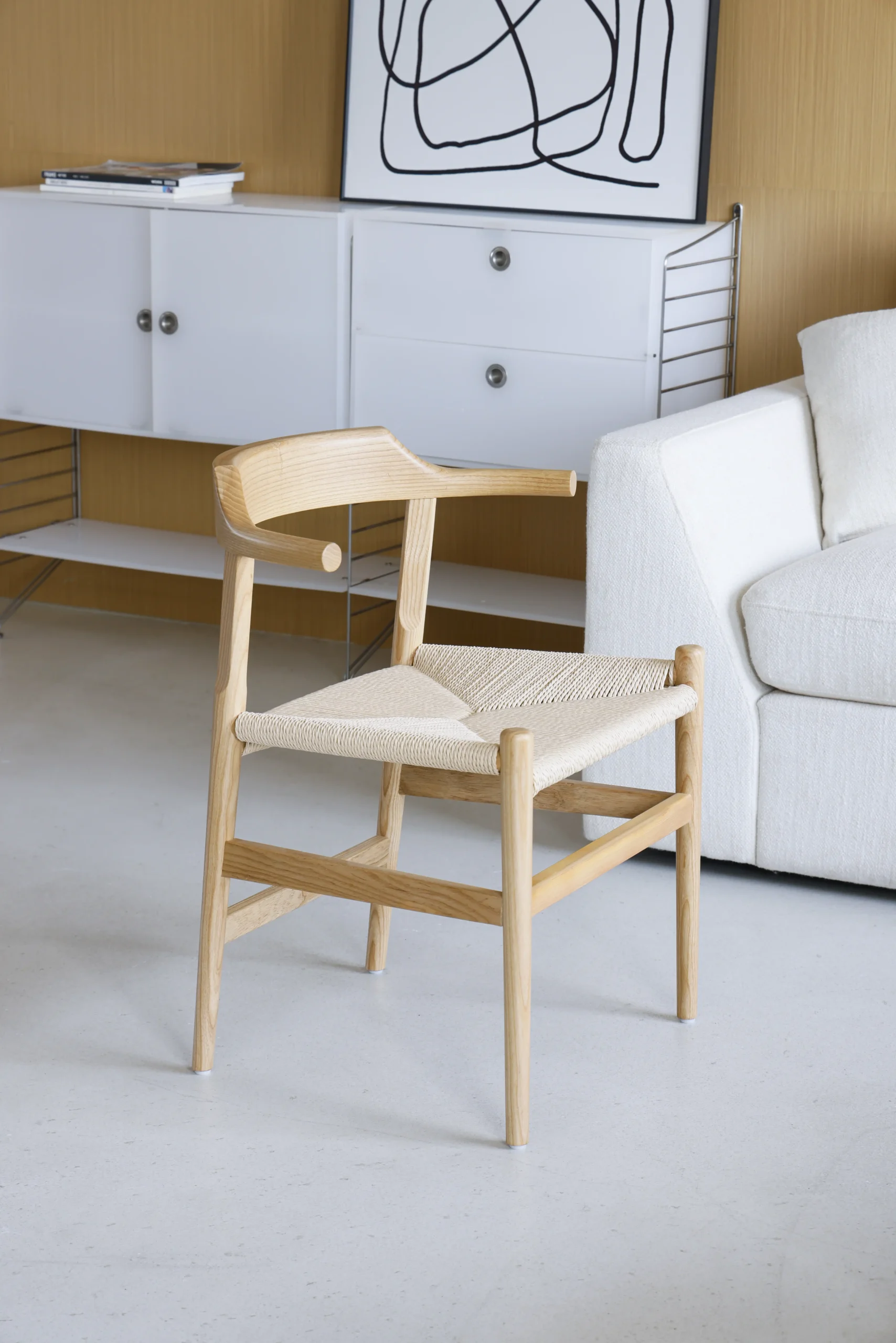 Photo of Hans Wegner's Final Chair, also known as PP68, placed in a living room, highlighting its clean lines, ergonomic design, and versatility, blending seamlessly into a stylish living space.