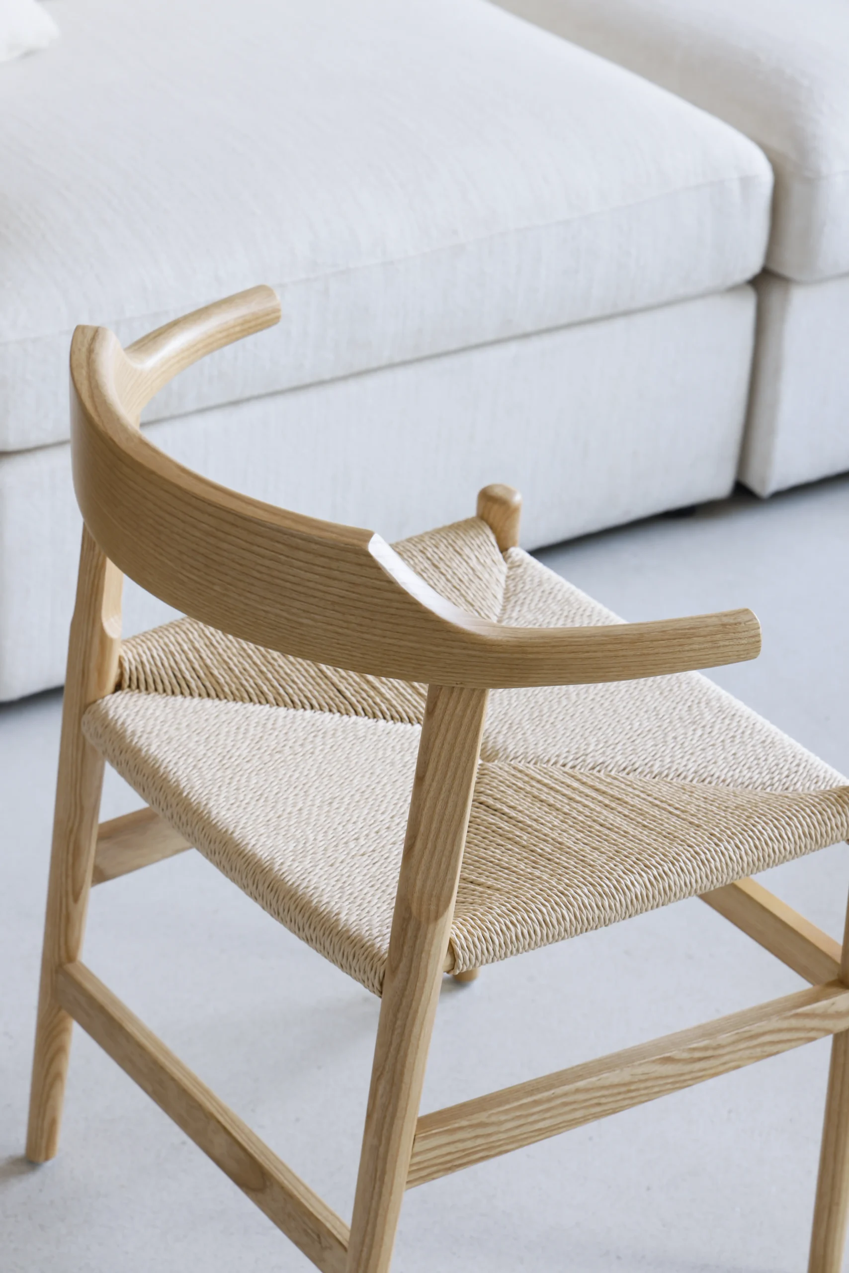 Photo of Hans Wegner's Final Chair, also known as PP68, placed in a living room, highlighting its clean lines, ergonomic design, and versatility, blending seamlessly into a stylish living space.