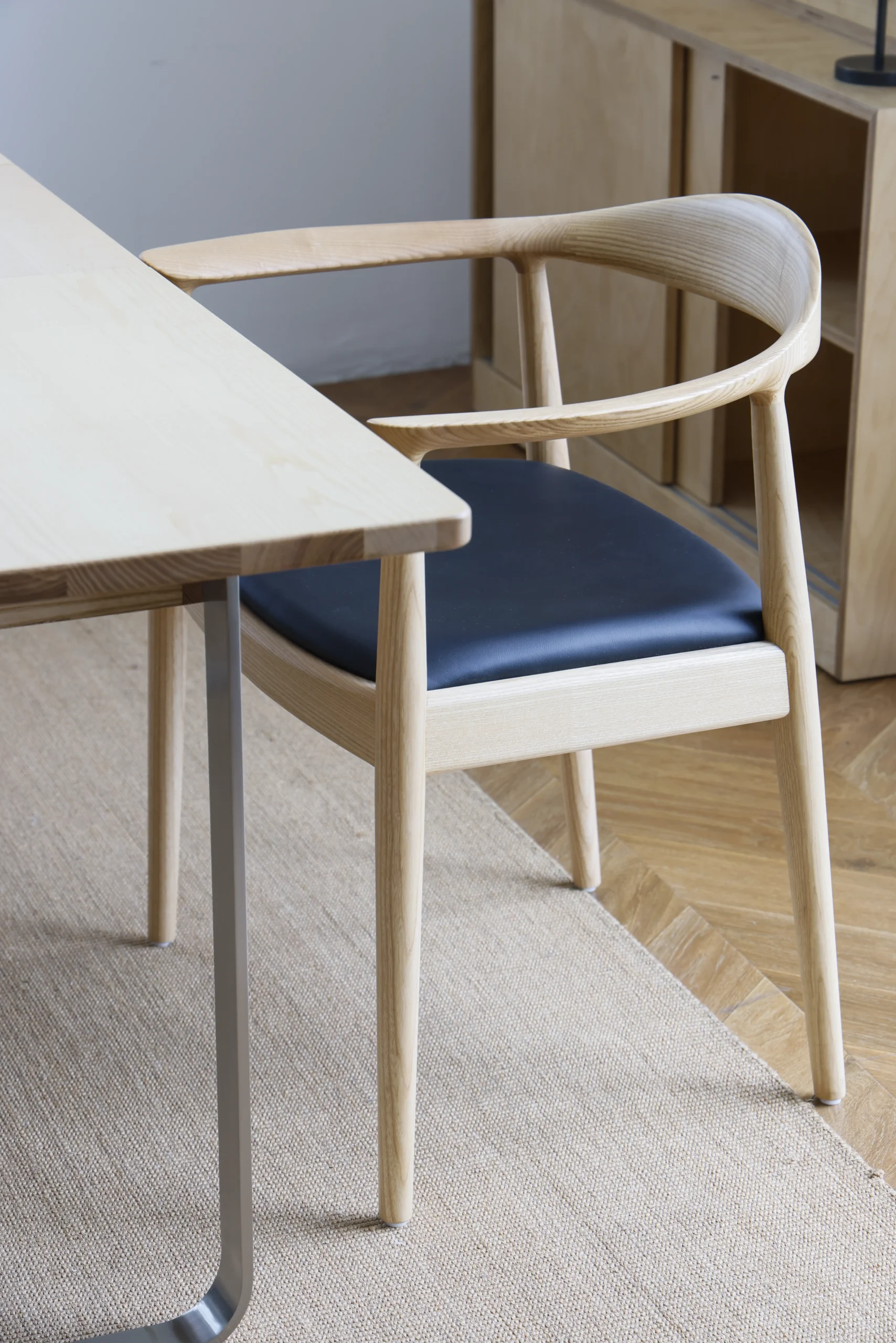 Designer timber Hans Wegner round chair upholstered with microfiber leather, placed in a stylish study room setting, highlighting its classic elegance and functional design.