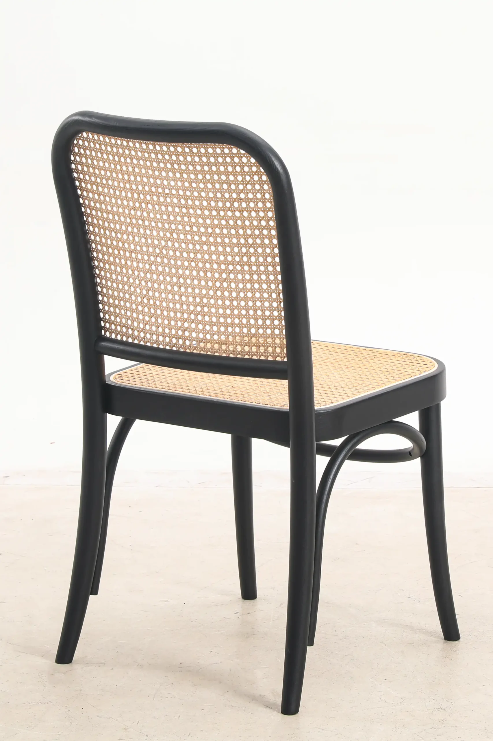 Photo of Josef Hoffmann's NO.811 chair from the back, showcasing the bentwood frame and woven cane backrest, highlighting its timeless and sophisticated design.