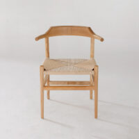 A wooden chair with a curved, sculpted backrest and woven beige seat, photographed against a plain white background.