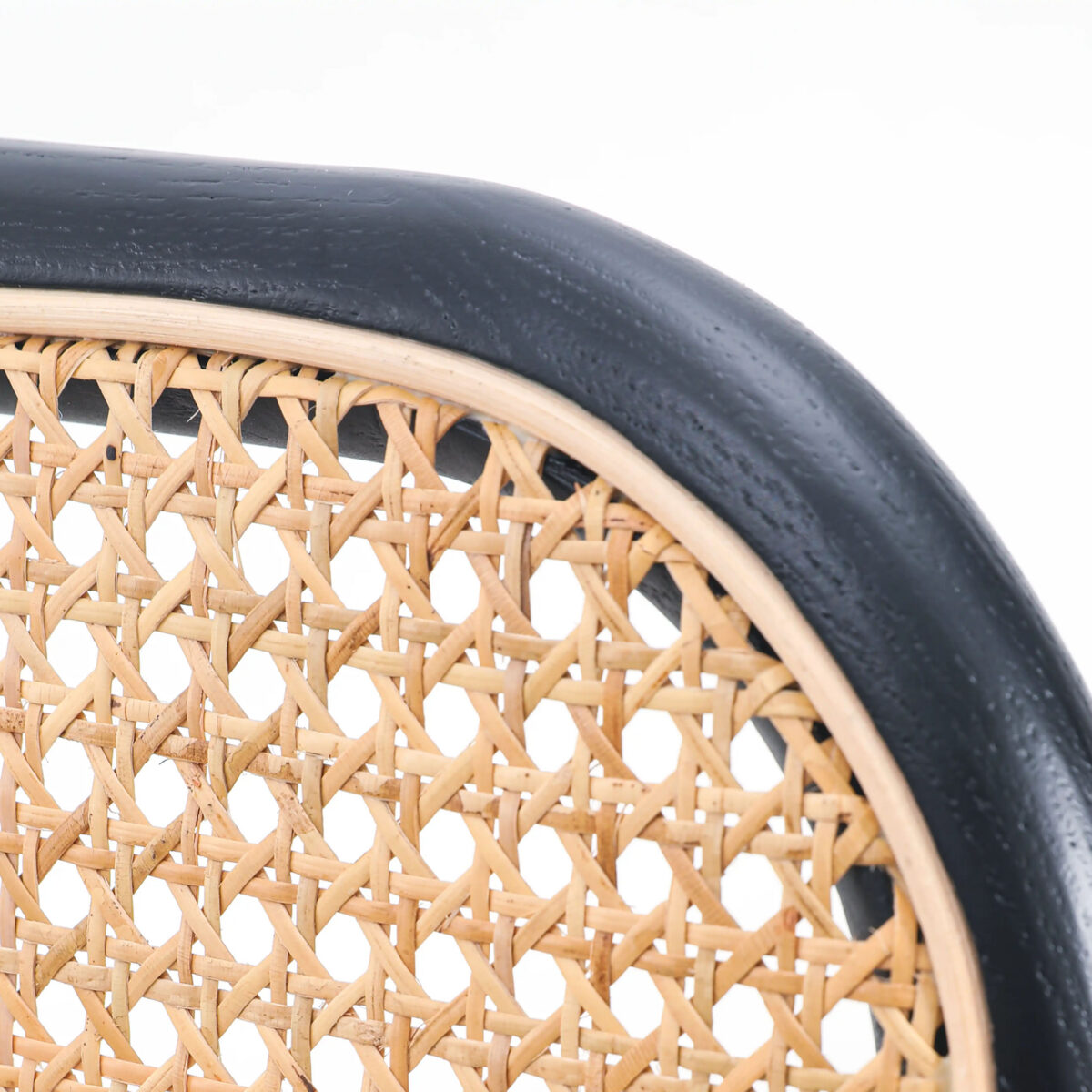 Rattan_B4 Close-up of a chair backrest featuring a woven cane pattern in natural wood colour, framed by a smooth, curved, black wooden border against a white background.
