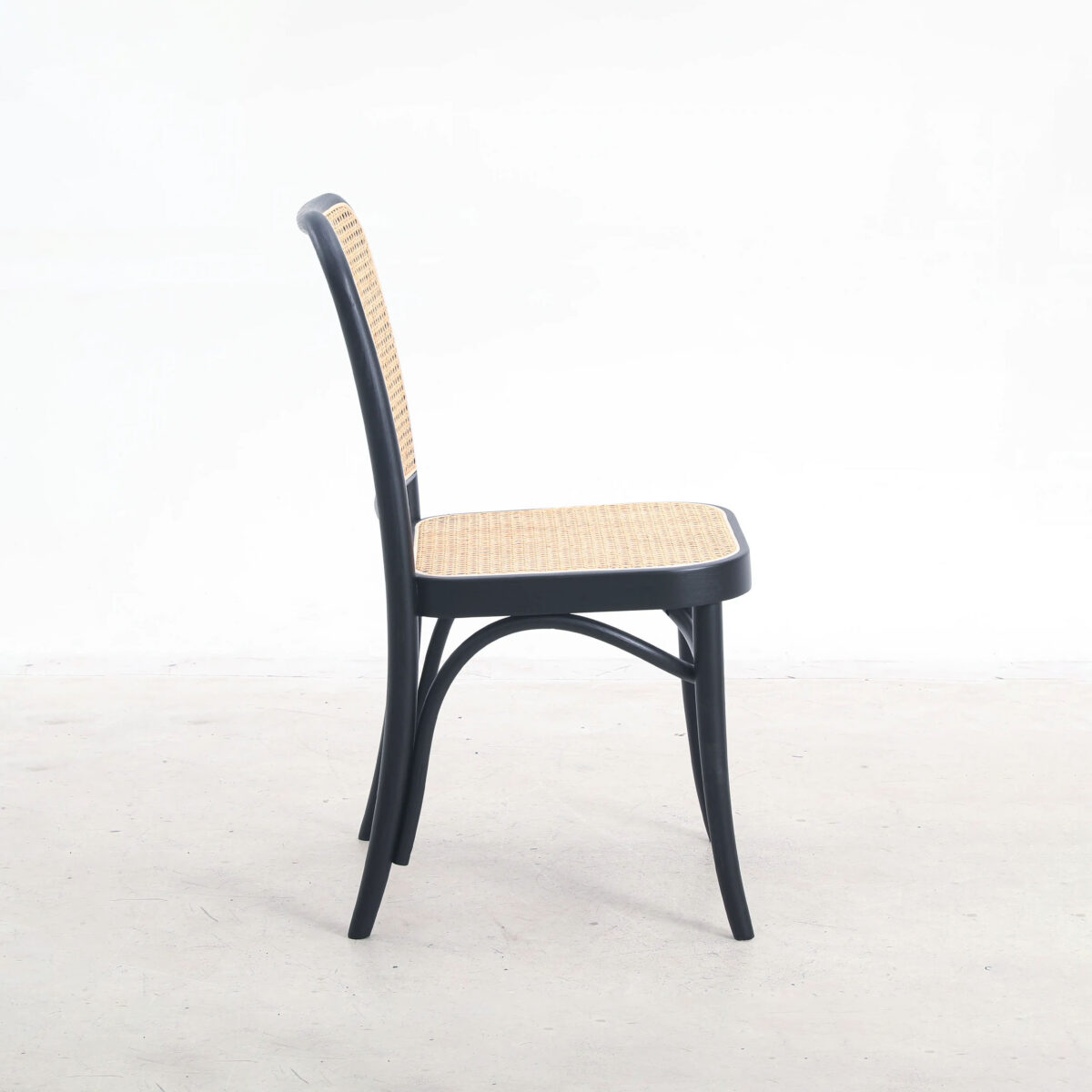 Rattan_B9 A black wooden chair with a woven rattan seat and backrest, shown from the side against a plain white background.