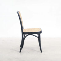 A black wooden chair with a woven rattan seat and backrest, shown from the side against a plain white background.