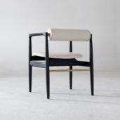 A modern chair with a black wooden frame, a rounded white-cushioned backrest, and a matching white seat, set against a plain light grey background.