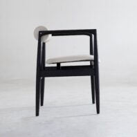A modern chair with a black wooden frame, white cushioned seat, and a round white backrest, placed on a light grey floor against a plain white background.