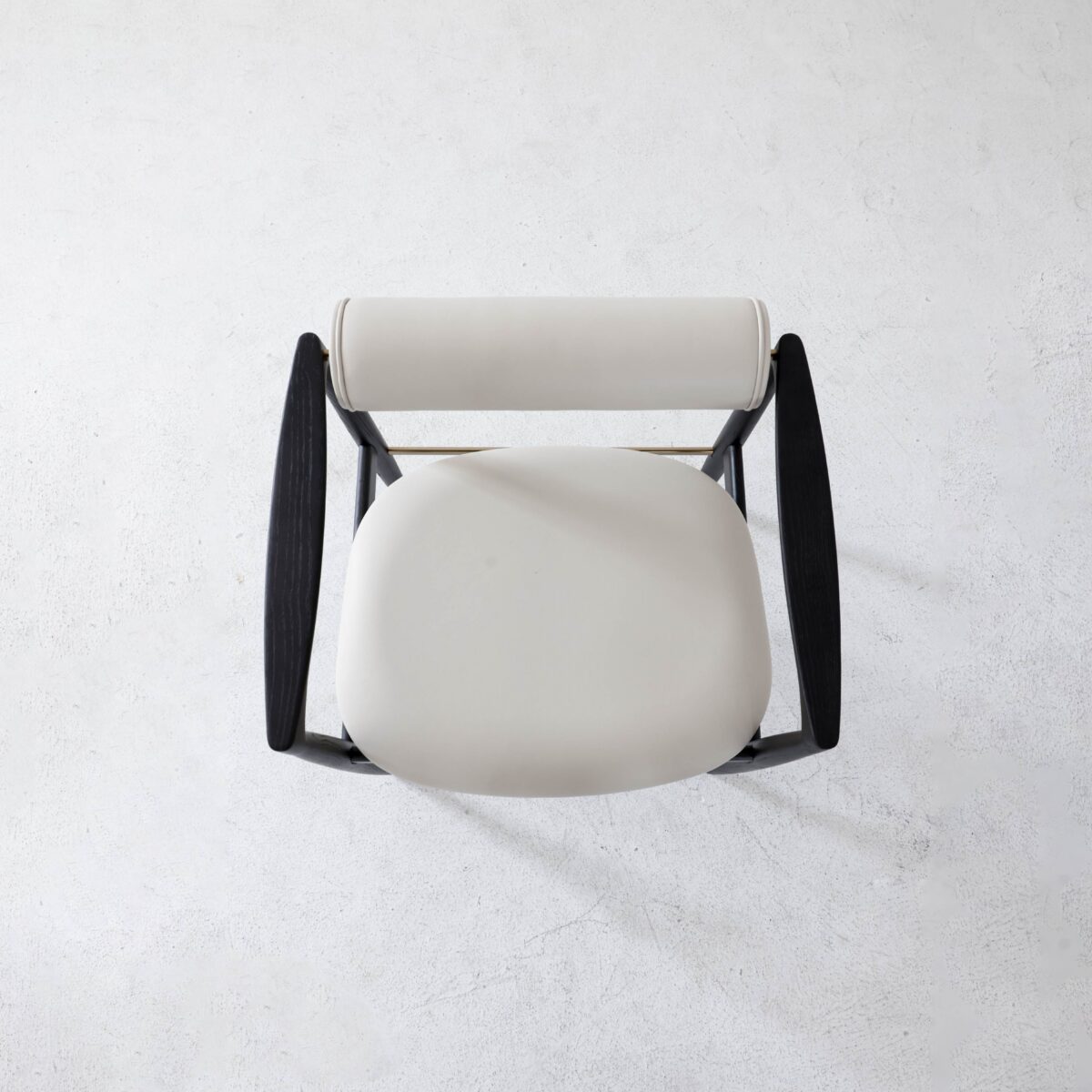 Black Frame + White Seat_B8 Top-down view of a modern chair with a round, white cushioned seat and backrest, and dark, curved wooden armrests on a light, textured floor.