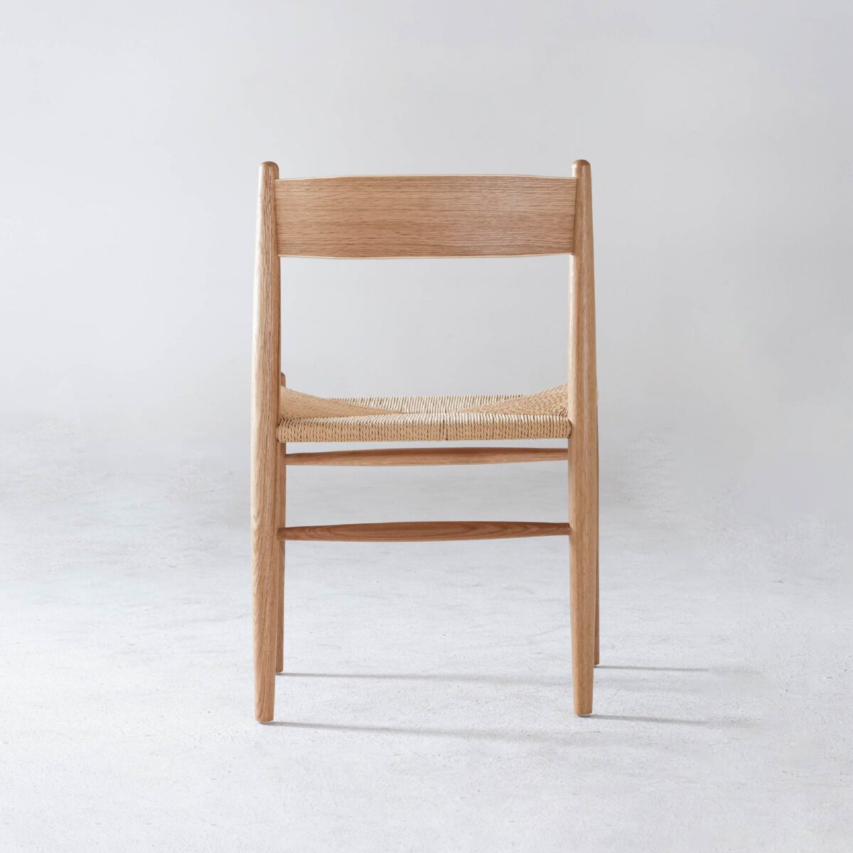 CH36 Chair_B2 A wooden chair with a natural finish and a woven seat, photographed from the front against a plain light grey background.