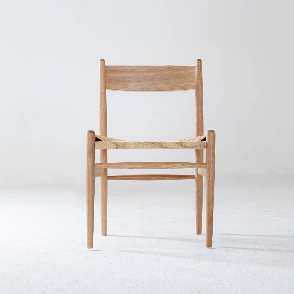 CH36 Chair_B7 A simple wooden chair with a woven seat and a straight backrest, shown against a plain white background.