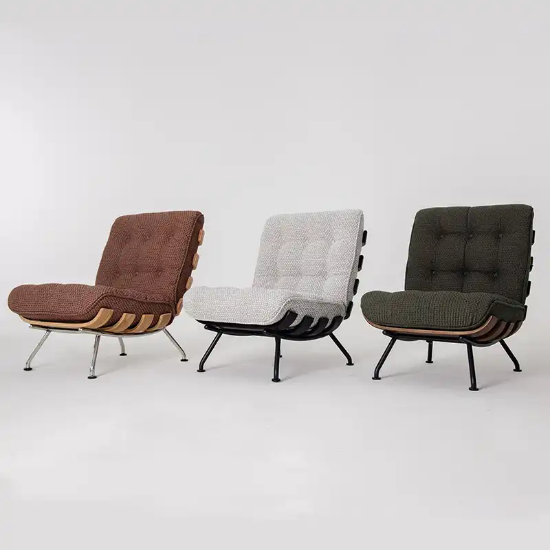 Three modern lounge chairs with tufted backs and seats, featuring curved wooden frames and metal legs. The chairs are upholstered in brown, light grey, and dark green fabrics, set against a plain white background.