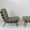 A modern lounge chair with matching ottoman, both featuring textured green cushions, black metal frames, and brown leather straps along the sides. The background is plain white.