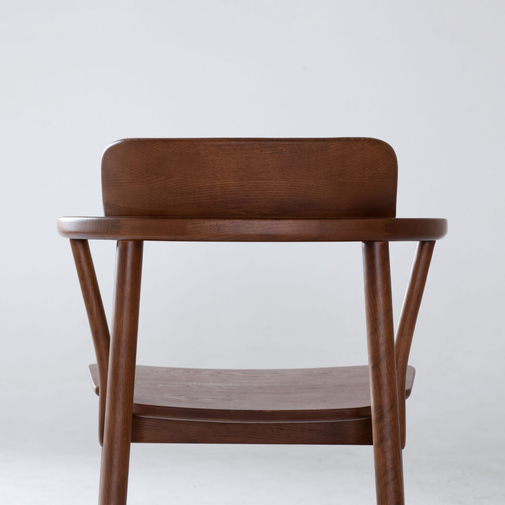 A wooden chair with a curved backrest and simple design, photographed against a plain white background.
