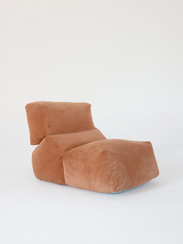 A sculptural brown cushioned lounge chair with an integrated extended seat, on a plain white background.