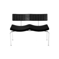 A modern black bench with a split backrest featuring small circular cut-outs, contoured seat, and metal legs, set against a white background.