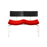 Modern bench with a wavy red cushioned seat, a black perforated backrest, and thin metal legs, photographed against a white background.