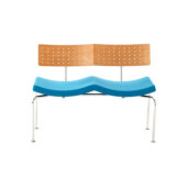 A modern bench with a perforated wooden backrest, a wavy blue seat, and metal legs, set against a plain white background.