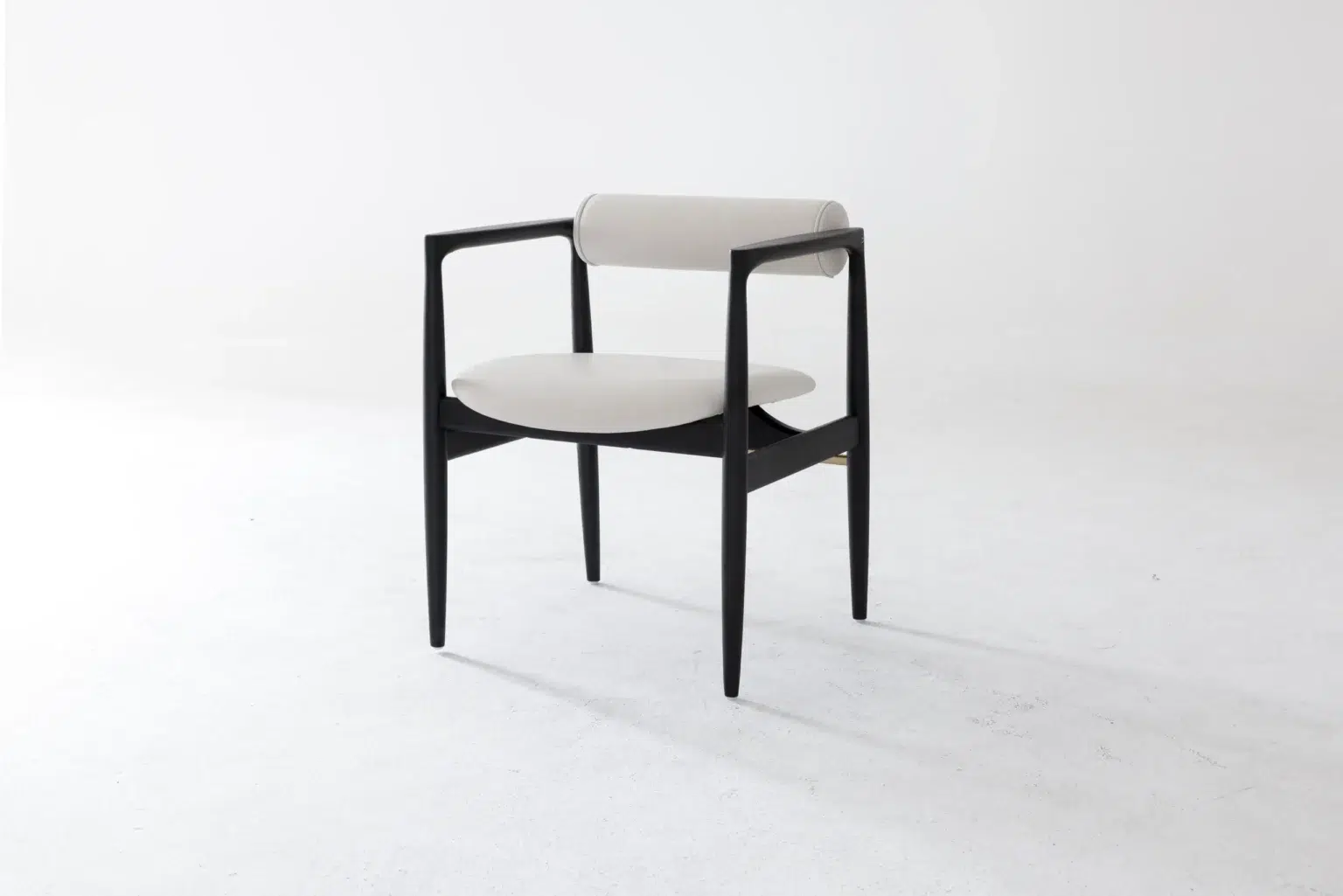 Front side view A modern chair with a black wooden frame, rounded legs, a circular light grey cushioned seat, and a matching cylindrical backrest, set against a plain white background.