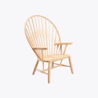 A wooden armchair with a high, rounded back made of vertical wooden spindles and a woven seat, set against a plain white background.