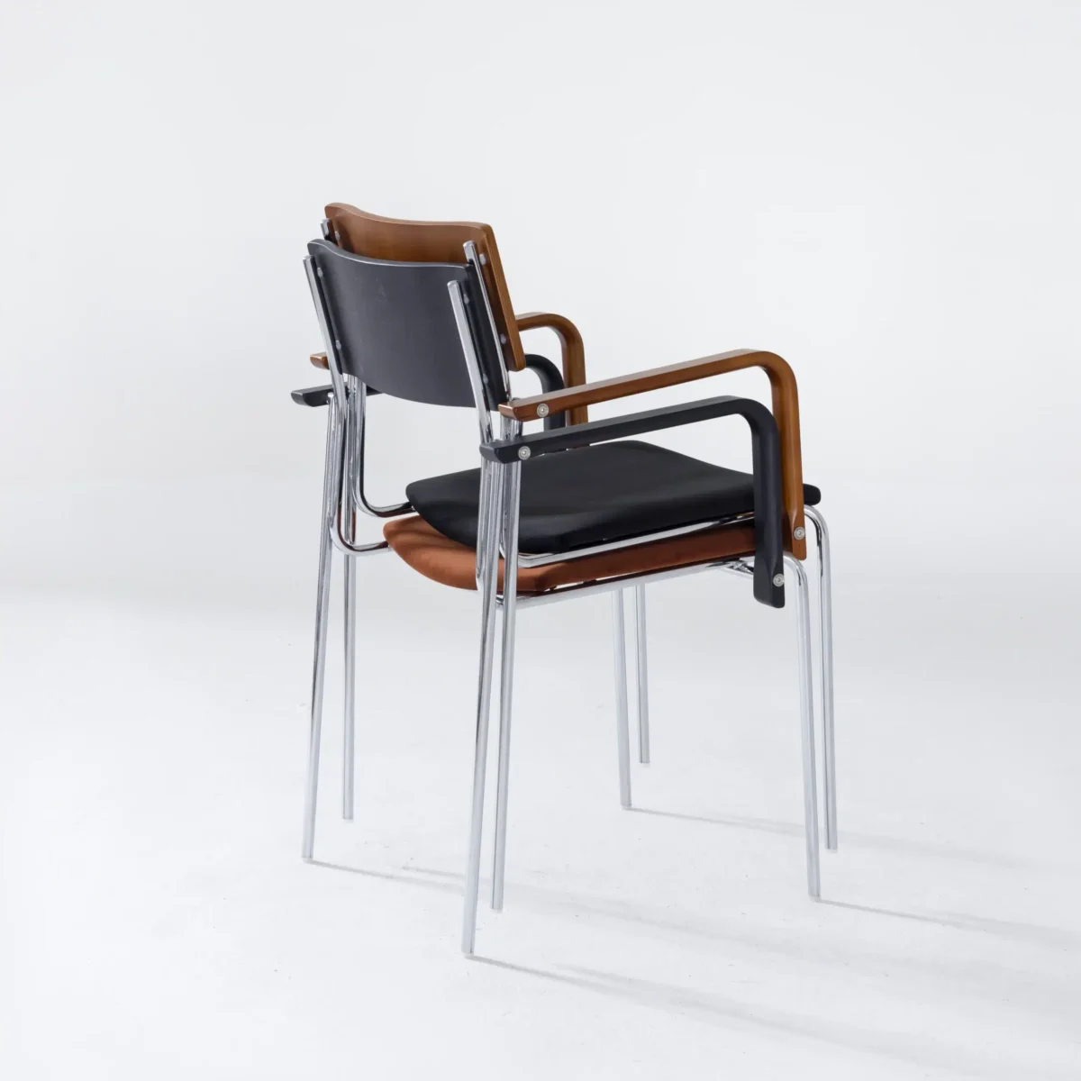 Knight Dining Chair__Black_Front Side View_Clean Bcakground_Stack Two modern chairs with black seats, brown backs, and chrome legs are stacked together on a white background. The chairs have minimalist armrests and a sleek, contemporary design.