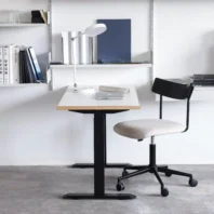 A desk with a chair and a lamp.