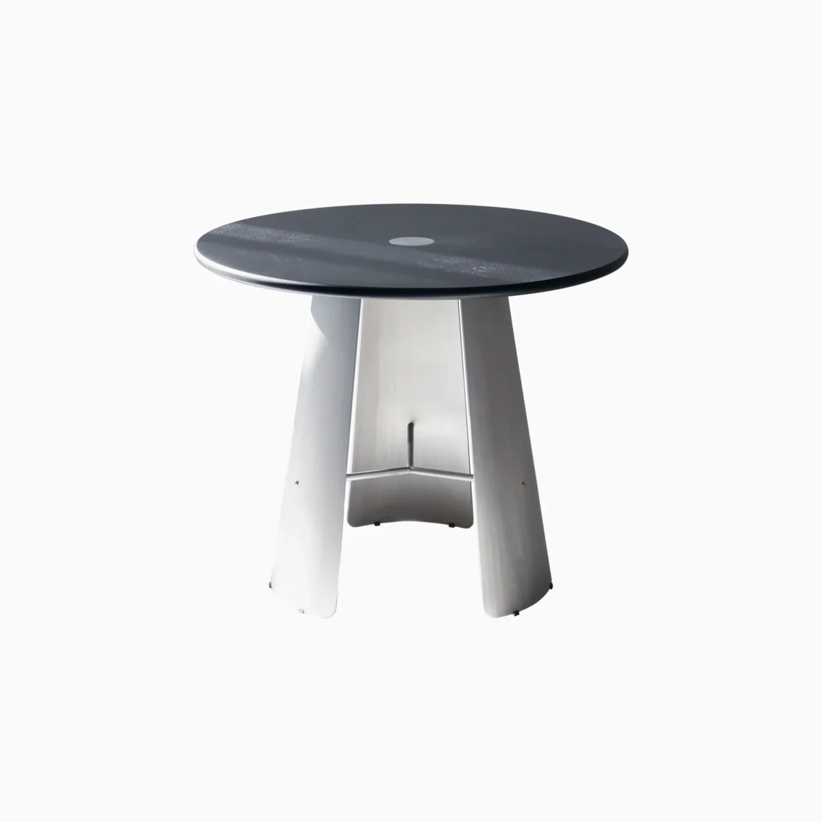 Monet Round Table_Main A modern round table with a dark tabletop and three angled, metallic silver legs, set against a plain white background.
