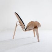 A modern wooden lounge chair with a sleek, sculptural design and black upholstered seat, set against a plain white background.