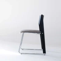A modern chair with a black backrest, grey cushioned seat, and a chrome metal frame, photographed from the side against a plain white background.