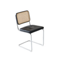 A modern chair with a chrome cantilever frame, a black cushioned seat, and a rectangular backrest featuring woven rattan. The design is minimalist and stylish, and the chair is set against a plain white background.