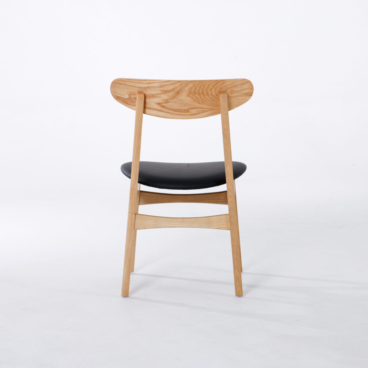 CH30P Chair_B29 A wooden chair with a curved backrest and a black cushioned seat, shown from the back on a plain white background.